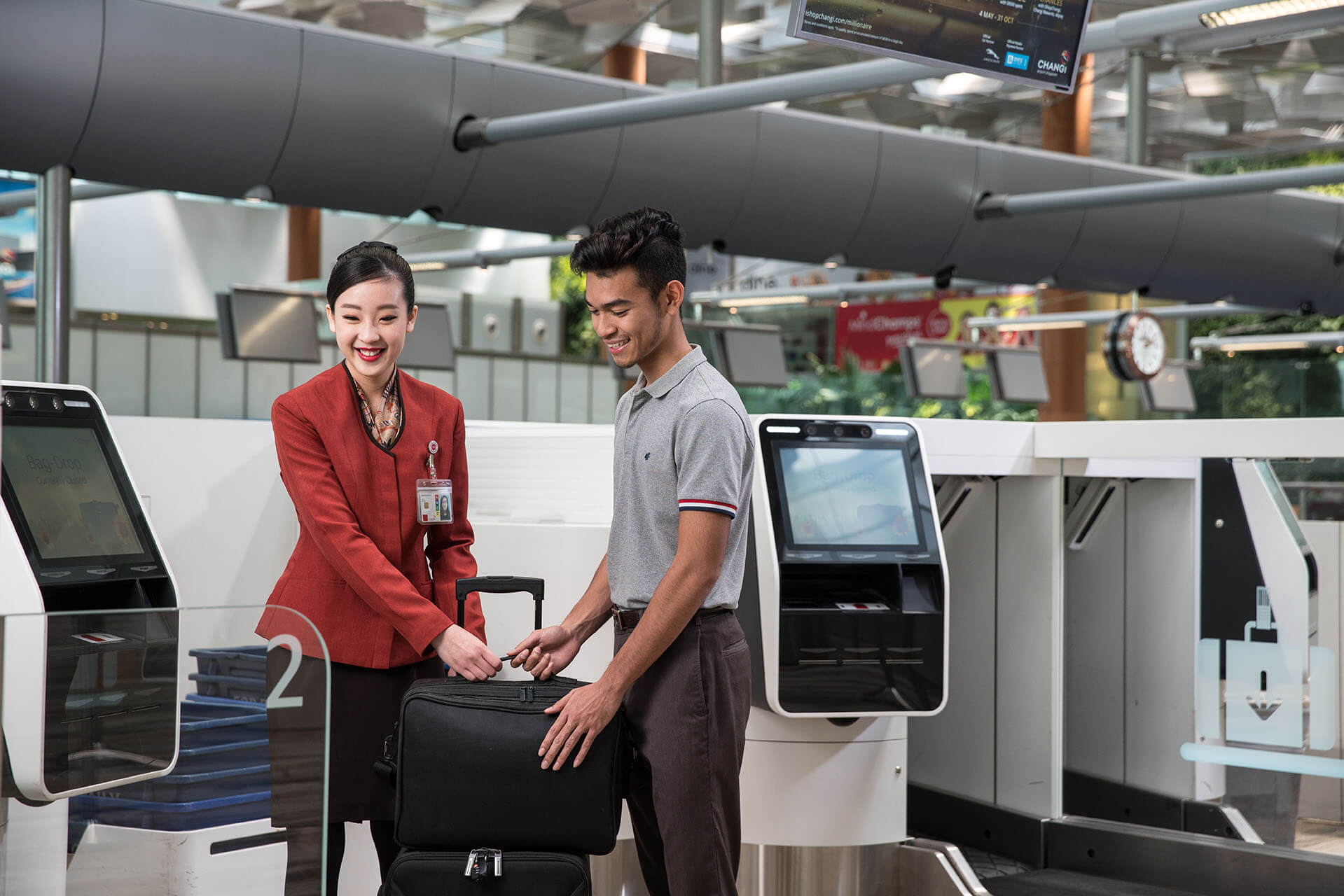 A student interning at a local airline helping a passenger check in