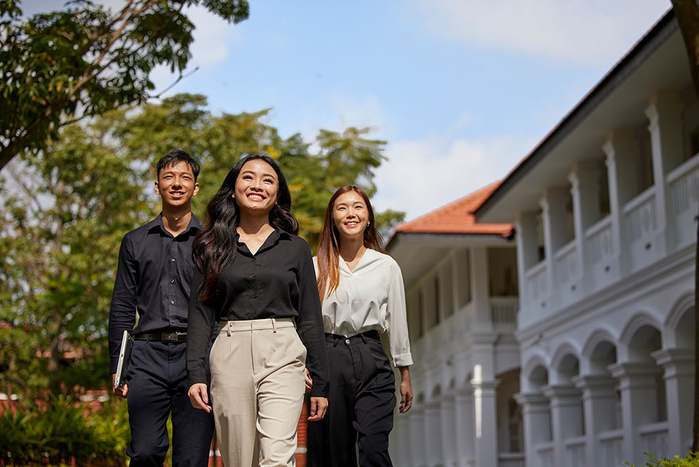 A group of students walking in the outdoors, near a tourist attraction