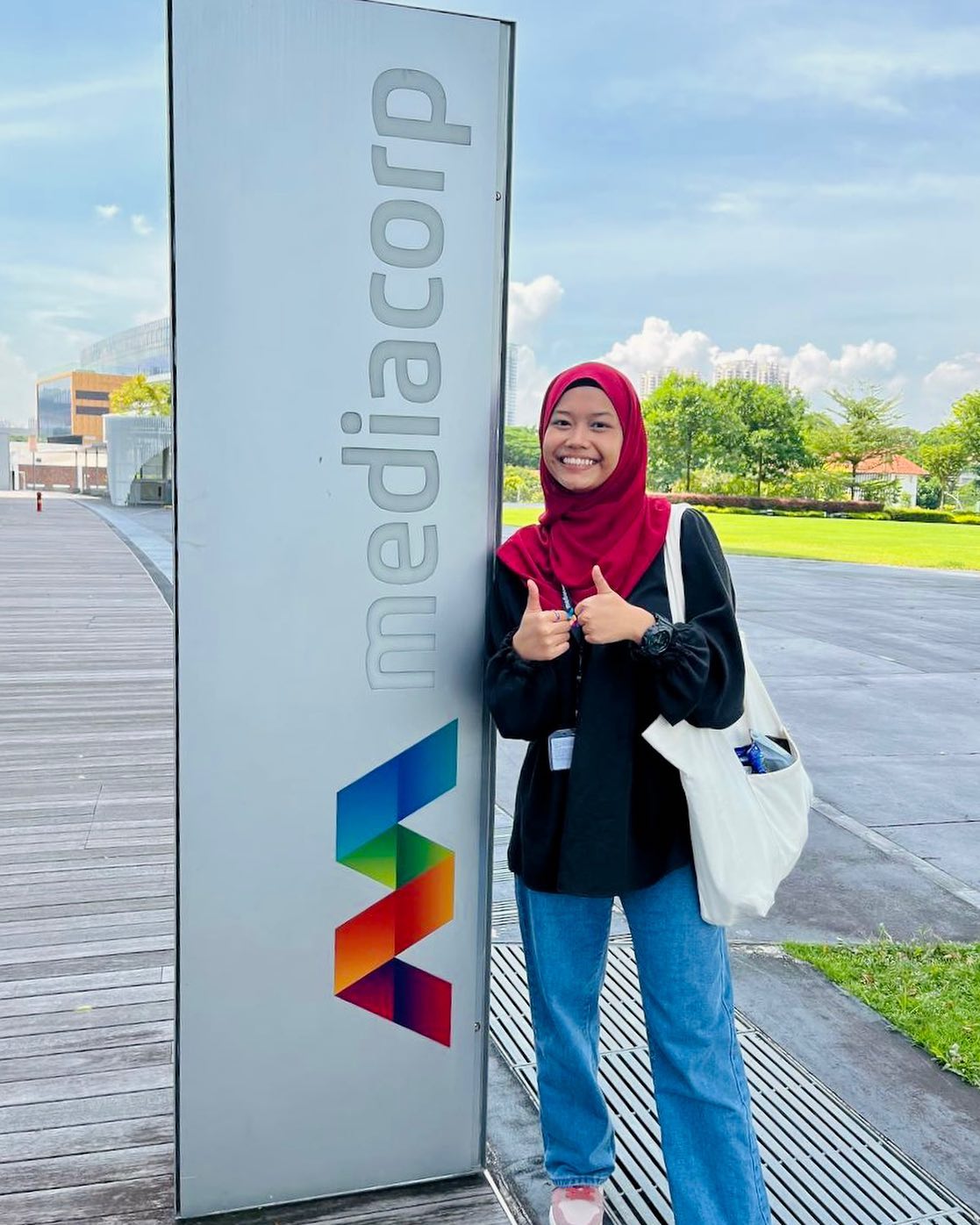 Humairah posing in front of a MediaCorp signage, where she had her internship