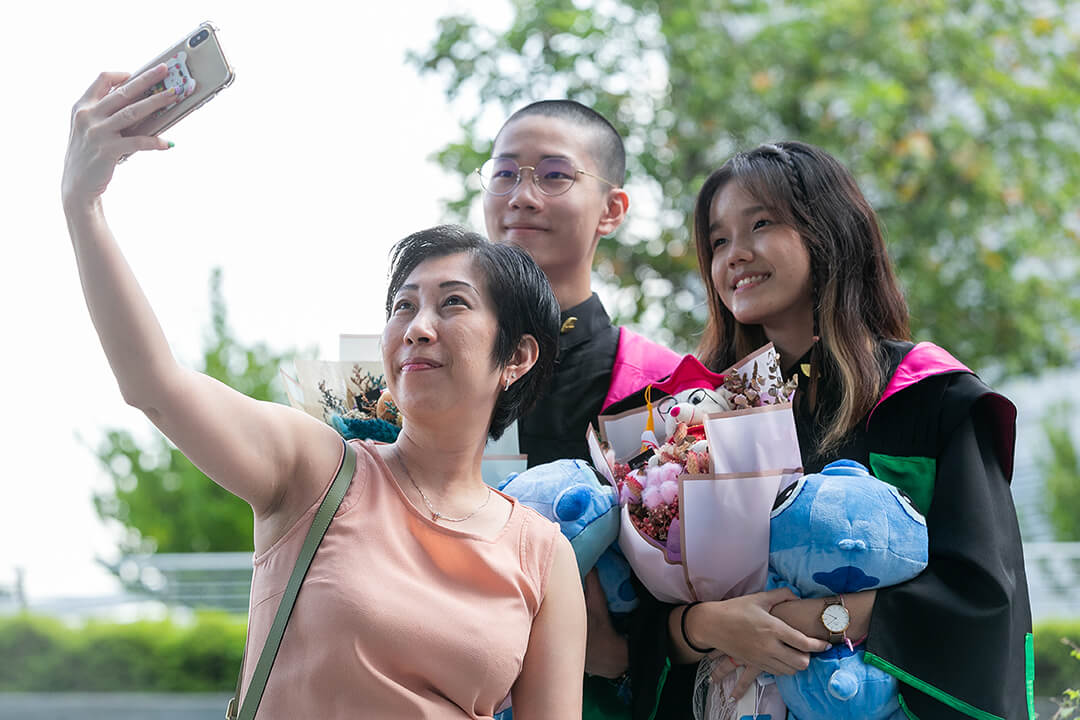 A mother taking a selfie with her children