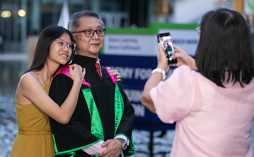 A lifelong learning graduate taking a photo with his family