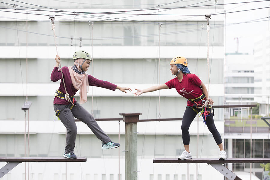 Participant lending a helping hand to a friend during the Partner Crossing activity. 